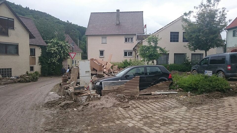 Zerstörungen und Hochwasser im Ort Braunsbach / Baden-Württemberg nach starken Regenfällen: mit Schlamm bedeckte Straße